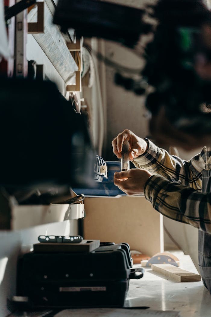 A dedicated craftsman meticulously working with tools in a workshop, highlighting skill and craftsmanship.